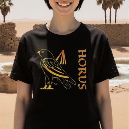 Black t-shirt featuring Horus, the Egyptian falcon god, in golden graphic print. Mythology tee.