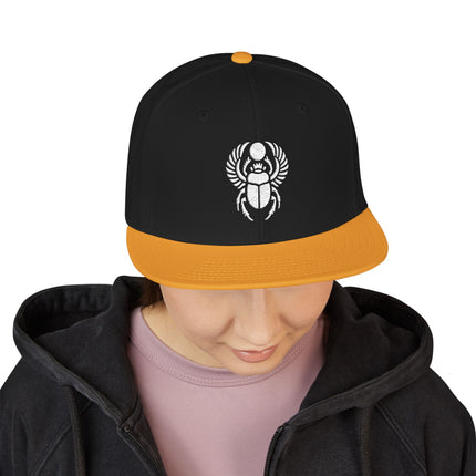 Black and orange snapback cap featuring an embroidered Khepri scarab beetle design.