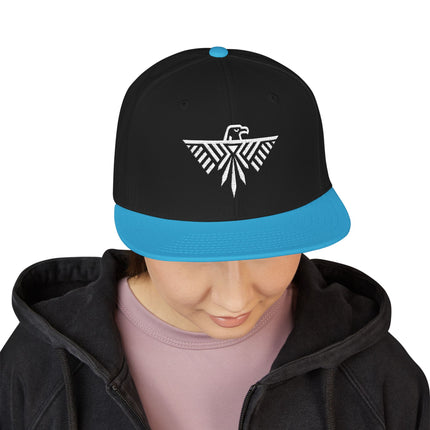 Geometric Thunderbird snapback hat with blue brim and tribal eagle embroidery.