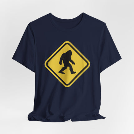 Bigfoot Sasquatch crossing warning sign graphic on a navy t-shirt.