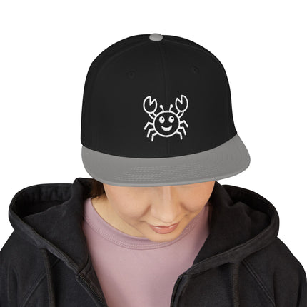 Black snapback cap featuring a cute embroidered smiling crab design.