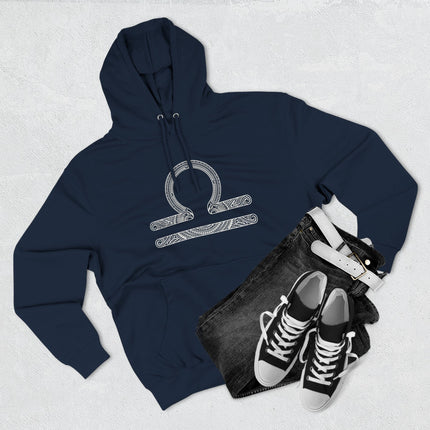 Intricate Libra zodiac scales symbol on a navy blue pullover hoodie for astrology lovers.