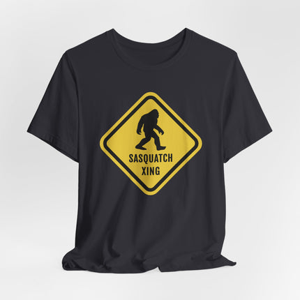 Caution sign graphic: Sasquatch crossing silhouette on a black t-shirt.