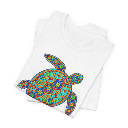 Vibrant Huichol sea turtle graphic on a white tee, featuring colorful Mexican indigenous folk art patterns.