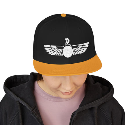 Black snapback hat with white embroidered Egyptian winged cobra Uraeus symbol.