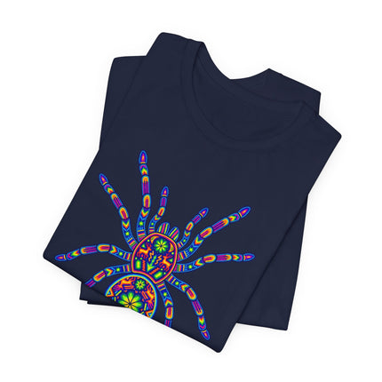 Vibrant Huichol tarantula art graphic on a dark blue tee, featuring rainbow mandalas and Mexican folk patterns.