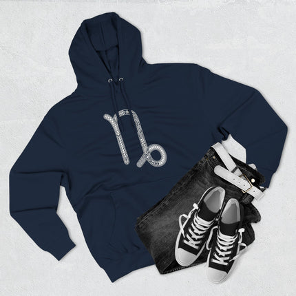 Ornate white Capricorn zodiac symbol printed on a dark blue unisex hoodie. Astrology star sign apparel.