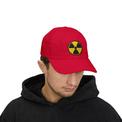 Embroidered nuclear hazard symbol on a red baseball cap.