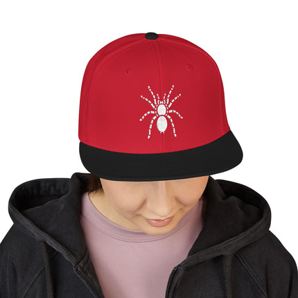 Red snapback cap featuring white embroidered spider art.