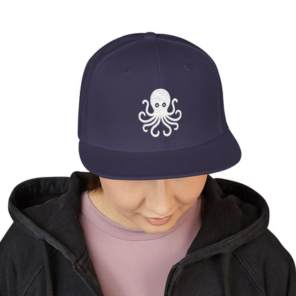 White embroidered octopus on a navy snapback cap for marine life lovers.