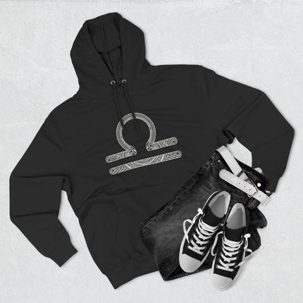 Detailed Libra zodiac scales symbol on a black pullover hoodie. Intricate astrology design.