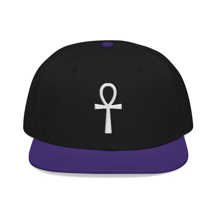 Black snapback hat with white embroidered Ankh symbol and purple bill.