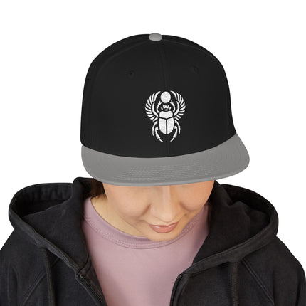 Black snapback hat featuring an embroidered Khepri scarab beetle design.