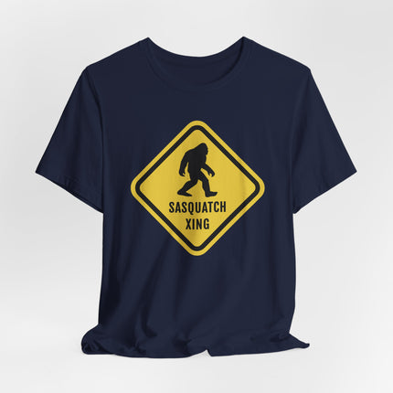 Bigfoot crossing caution sign graphic on a navy t-shirt.
