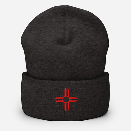 Black cuffed beanie embroidered with Zia Sun and red directional symbol.