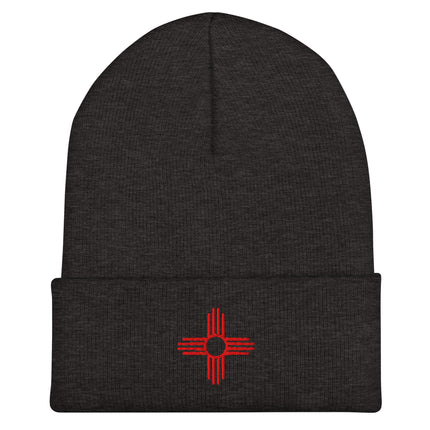 Embroidered Zia Sun beanie with red four-direction symbol design.