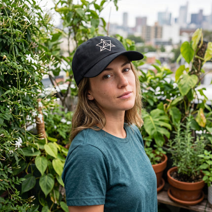 Black baseball cap featuring white embroidered Merkaba sacred geometry symbol.