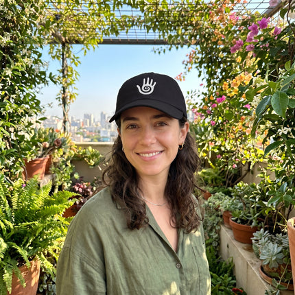 Black baseball cap embroidered with the white Hopi Healing Hand symbol.