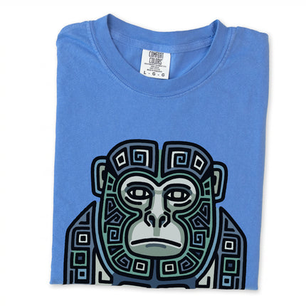 Geometric Mayan monkey tribal art graphic printed on a blue and green unisex t-shirt.