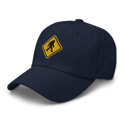 Embroidered cap featuring a Bigfoot crossing sign and sasquatch warning symbol design.