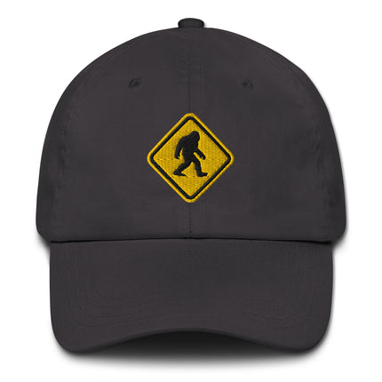 Embroidered Bigfoot crossing sign hat featuring a sasquatch warning symbol cap design.