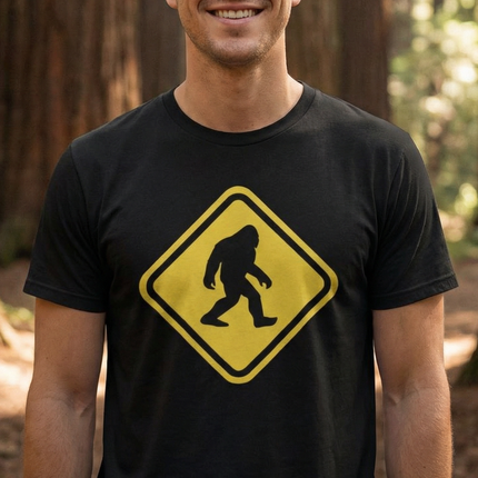 Bigfoot crossing warning sign graphic tee on a black shirt.