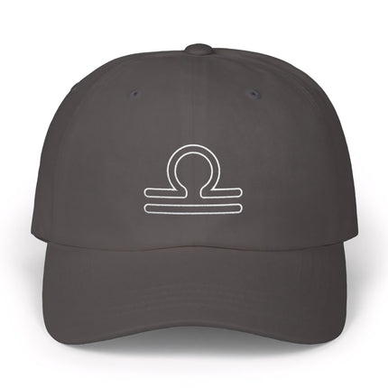 Libra zodiac scales symbol embroidered on a dark gray baseball cap.