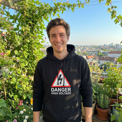Black pullover hoodie featuring a high voltage danger warning sign graphic.