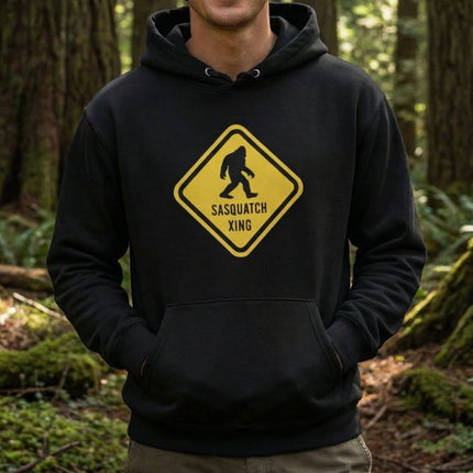 Black hoodie with yellow Sasquatch crossing warning sign graphic.