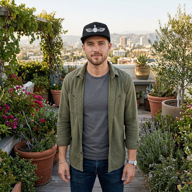 Black snapback hat featuring an embroidered Egyptian winged sun disk Uraeus symbol.