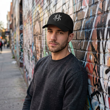 Embroidered spider logo on a black baseball cap.