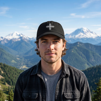 Black baseball cap featuring the embroidered Zia Sun symbol, a cultural design from New Mexico.