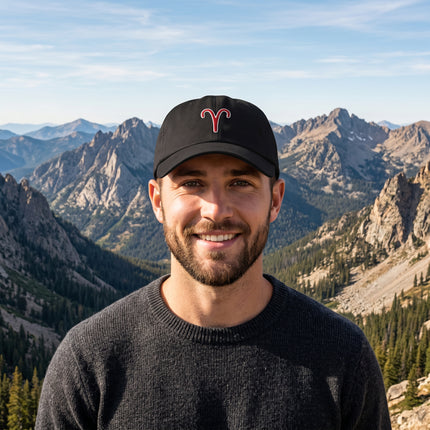 Black baseball cap featuring a red embroidered Aries zodiac symbol.
