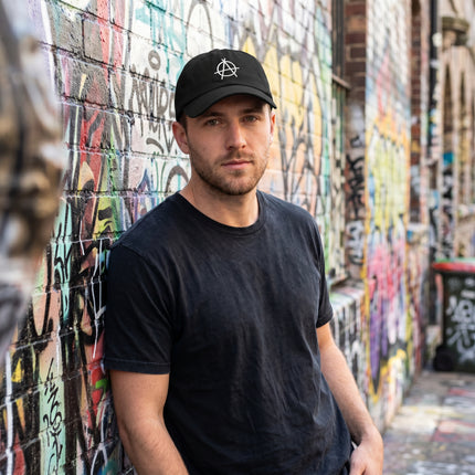 Black baseball cap featuring an embroidered anarchy symbol.