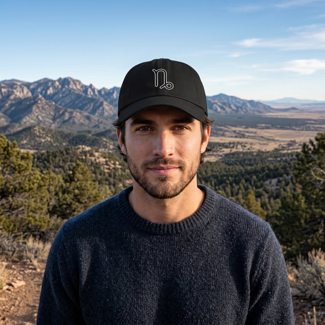 Black baseball cap featuring a minimalist embroidered Capricorn zodiac symbol.