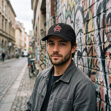 Black baseball cap featuring red embroidered anarchy symbol. Streetwear graphic cap.