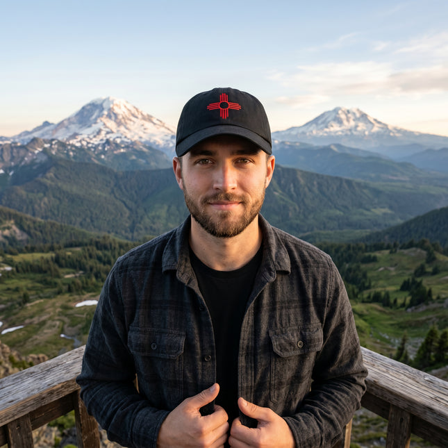 Embroidered black baseball cap featuring the Zia Sun symbol.