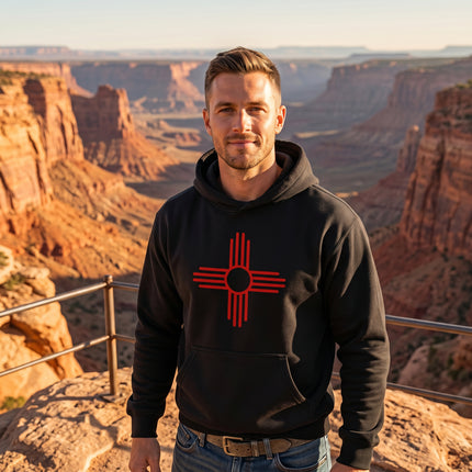 Black pullover hoodie featuring the red Zia Sun Symbol graphic print. Unisex cultural apparel.