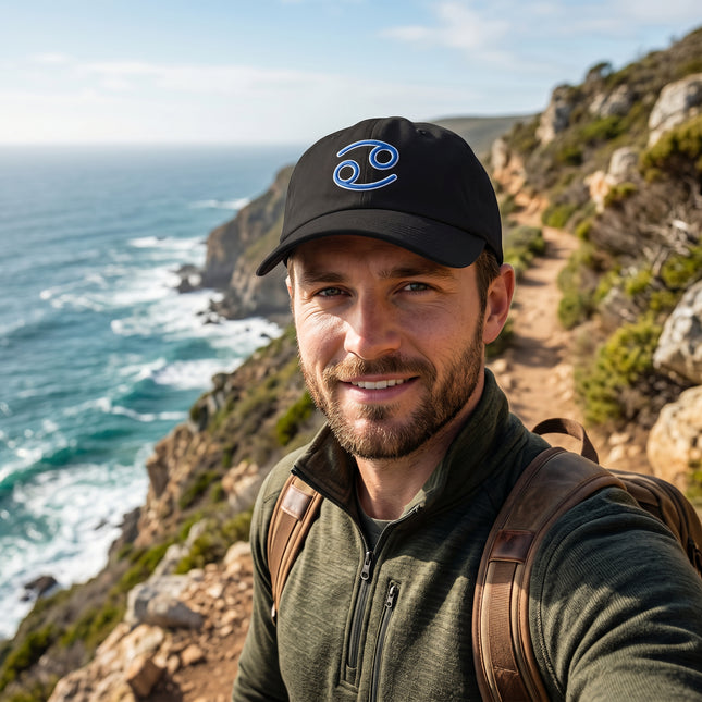 Black baseball cap featuring blue embroidered Cancer zodiac sign embroidery.