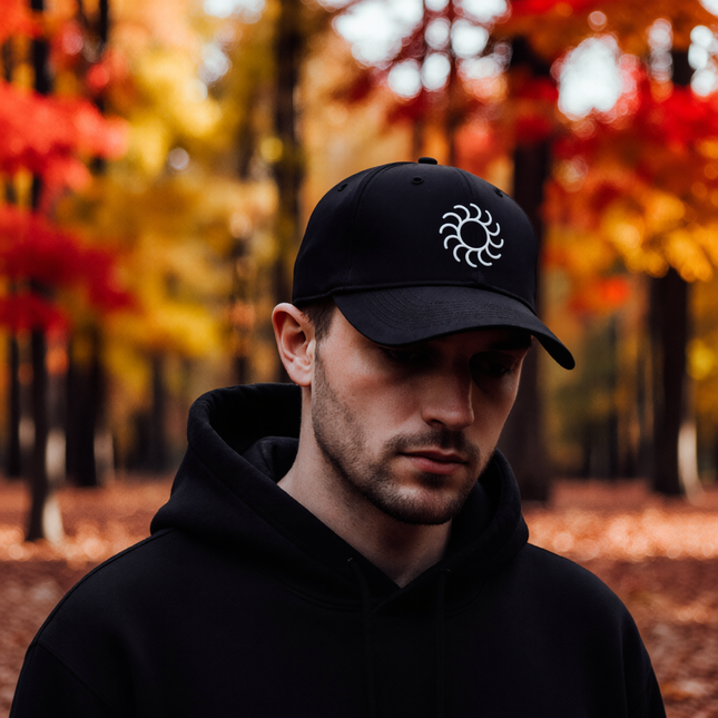 Black baseball cap with white embroidered sun symbol. Minimalist occult streetwear accessory.
