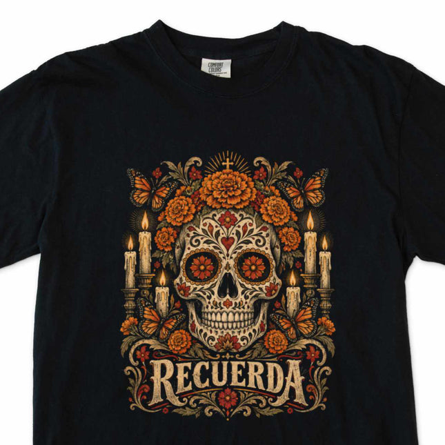 Decorated skull, marigolds, and candle artwork on a black t-shirt.